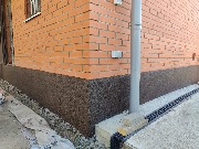 Цоколь дома утеплён фасадным пенопластом, выполнена отделка декоративной штукатуркой - мраморная крошка