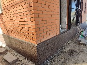 Цоколь дома утеплён фасадным пенопластом, выполнена отделка декоративной штукатуркой - мраморная крошка