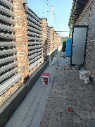 Цоколь забора предварительно обклеен фасадным пенопластом, установлены усиливающие уголки, ведутся армировочные работы