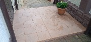 Ведутся работы по укладке керамогранитной плитки во дворе частного дома